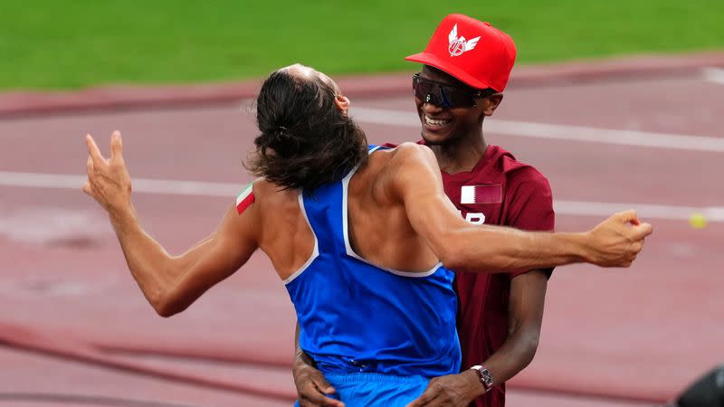 Foto del domingo del italiano Gianmarco Tamberi y el qatarí Mutaz Essa Barshim celebran tras el oro compartido en salto en alto.