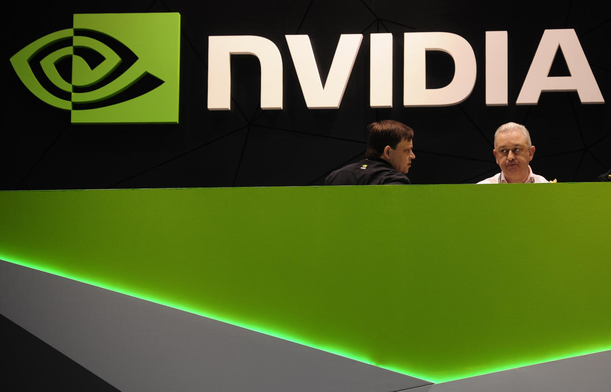 FILE - In this file photo dated Thursday, Feb. 27, 2014, people gather in the Nvidia booth at the Mobile World Congress mobile phone trade show in Barcelona, Spain. U.K regulators said Wednesday Jan. 6, 2021, they are investigating graphics computer chip maker Nvidia's $40 billion purchase of chip designer Arm Holdings over concerns about its effect on competition. (AP Photo/Manu Fernandez, FILE)