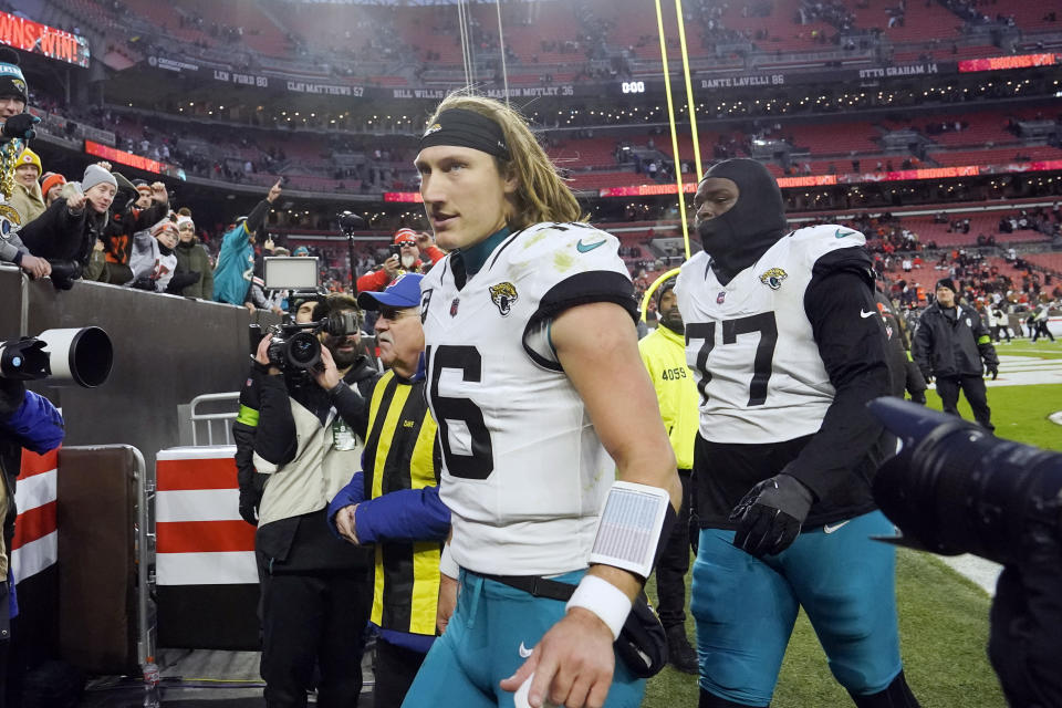 Jacksonville Jaguars quarterback Trevor Lawrence (16) walks off the field with offensive tackle Anton Harrison (77) after an NFL football game against the Cleveland Browns, Sunday, Dec. 10, 2023, in Cleveland. (AP Photo/Sue Ogrocki)