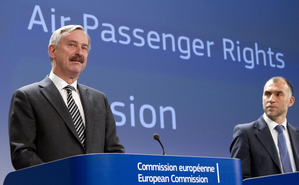 European Commissioner for Transport Siim Kallas, left, speaks during a media conference at EU headquarters in Brussels on Wednesday, March 13, 2013. The European Union is considering beefed up measures for stranded passengers to get compensation and find quicker ways to get home. Man at right unidentified. (AP Photo/Virginia Mayo)