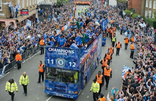 Chelsea players wave to fans as they ride during an open-top bus parade along Kings Road in west London