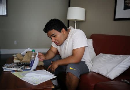 Raul Contreras, 19, of Honduras, who is seeking refugee status in Canada, looks at job-seeking materials provided by the YMCA at a long-stay hotel in Toronto, Ontario, Canada April 9, 2017. REUTERS/Chris Helgren