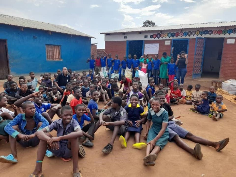 A group of children in Africa smile after participating in HateLess programming.