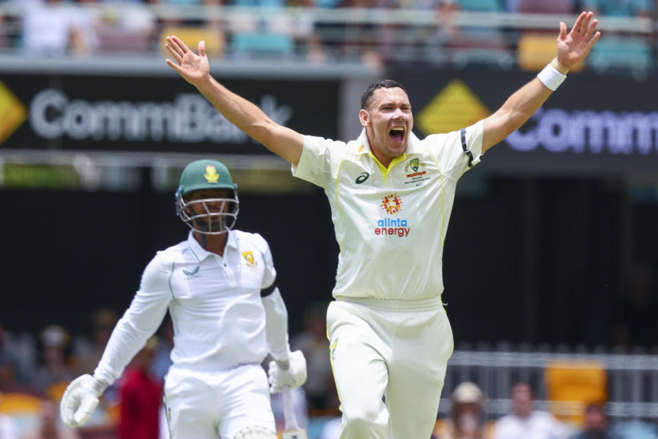 Australia's Scott Boland, right, appeals successfully for the wicket of South Africa's Khaya Zondo, left, during the first cricket test between South Africa and Australia at the Gabba in Brisbane, Australia, Saturday, Dec. 17, 2022. (AP Photo/Tertius Pickard)