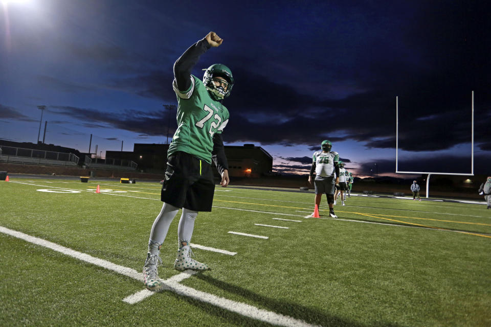 Javin Lujan Lopez, 17, trains during a socially-distanced football practice at Pojoaque High School, in Pojoaque, N.M., Feb. 11, 2021. High school athletes trained in five-person pods for the past year because of the pandemic. (AP Photo/Cedar Attanasio)