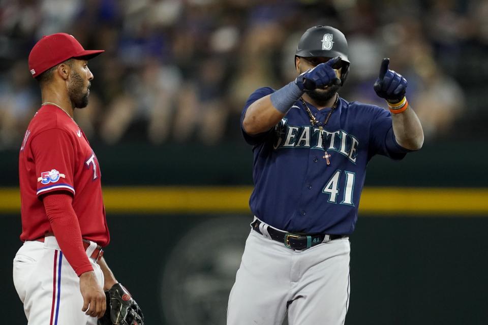 Seattle Mariners' Carlos Santana (41) celebrates his double next to Texas Rangers second baseman Marcus Semien during the fourth inning of a baseball game in Arlington, Texas, Friday, Aug. 12, 2022. (AP Photo/Tony Gutierrez)