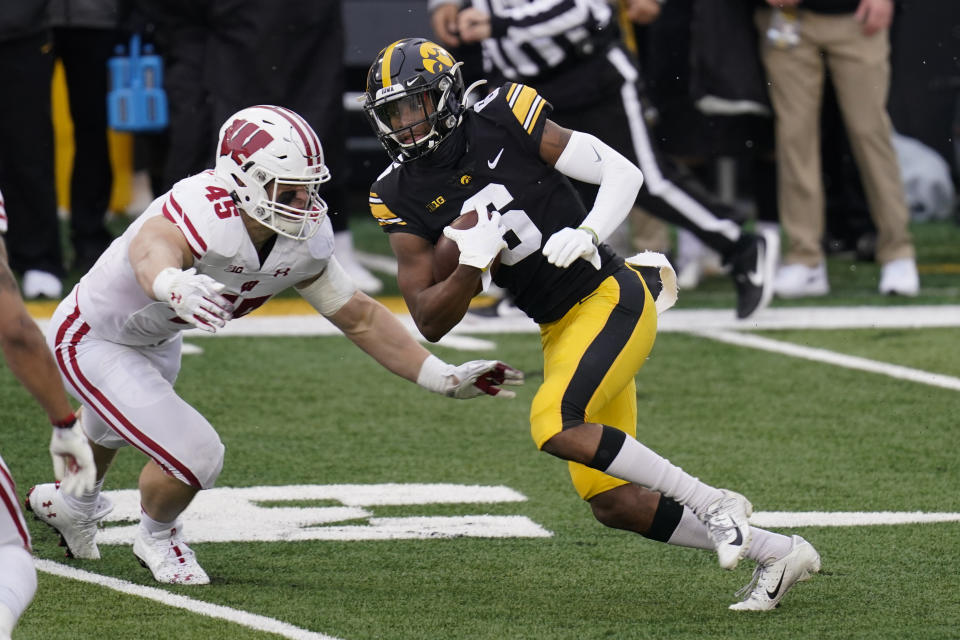 Iowa wide receiver Ihmir Smith-Marsette (6) runs from Wisconsin linebacker Leo Chenal, left, after catching a pass during the first half of an NCAA college football game, Saturday, Dec. 12, 2020, in Iowa City, Iowa. (AP Photo/Charlie Neibergall)