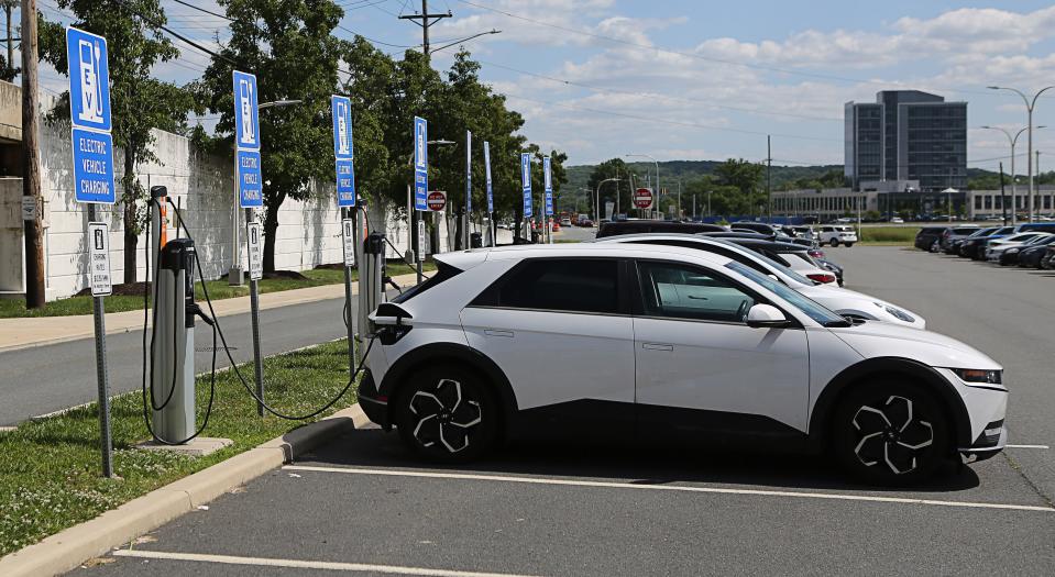 A row of vehicles charging at electric charging stations at the Thomas R. Carper Newark Station.