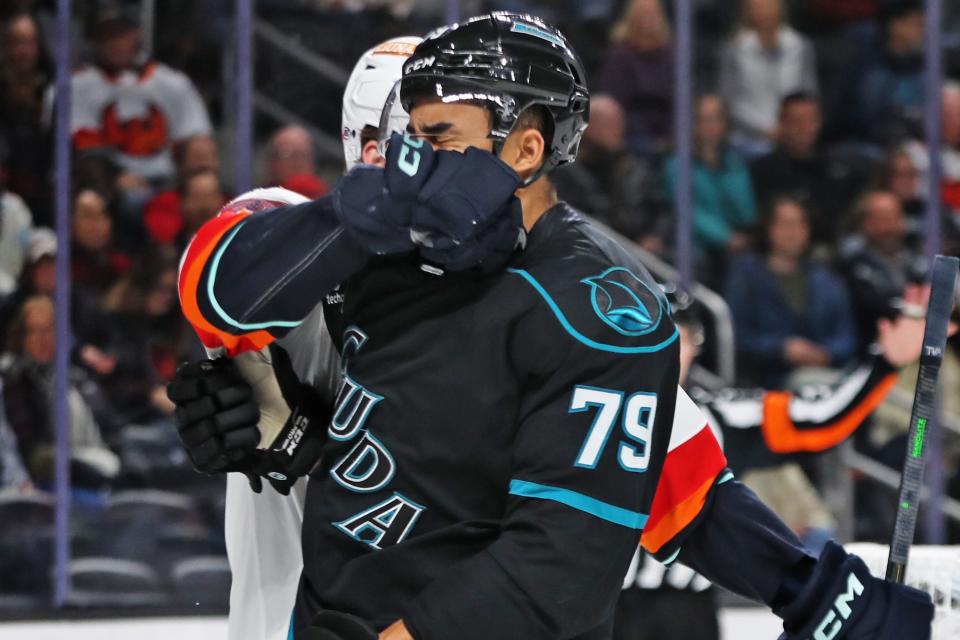 Coachella Valley Firebirds right wing Kole Lind punches San Jose Barracuda defensemen Montana Onyebuchi during first period at Acrisure Arena in Palm Desert, Calif., on Tuesday, Jan. 10, 2023.