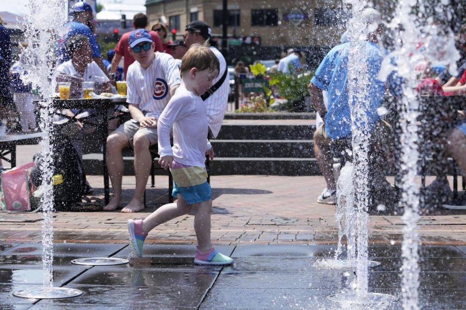 A kid cools off at Gallagher Way park fountain during hot weather in Chicago, Sunday, June 16, 2024. (AP Photo/Nam Y. Huh)