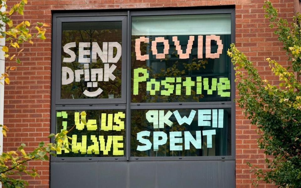 Signs made by students are displayed in a window of their locked down accommodation building in Manchester, England - Christopher Furlong/Getty Images