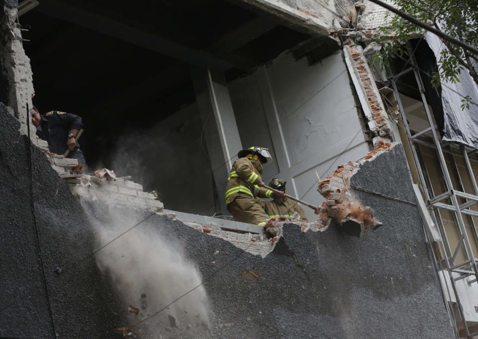 A firefighter works to demolish a damaged wall of a building after a 6.4 magnitude earthquake in Mexico City May 8, 2014. The earthquake shook Mexico City on Thursday, rattling buildings and prompting office evacuations. The U.S. Geological Survey put the quake epicenter in the western Mexican state of Guerrero at a depth of 14.9 miles (23.9 km) just inland from the Pacific Coast. (REUTERS/Henry Romero)