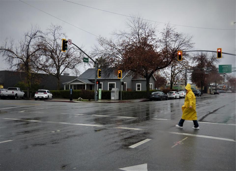 Leia Gribner of Redding crosses Pine Street in downtown Redding during a rainstorm Wednesday, Jan. 4, 2023.