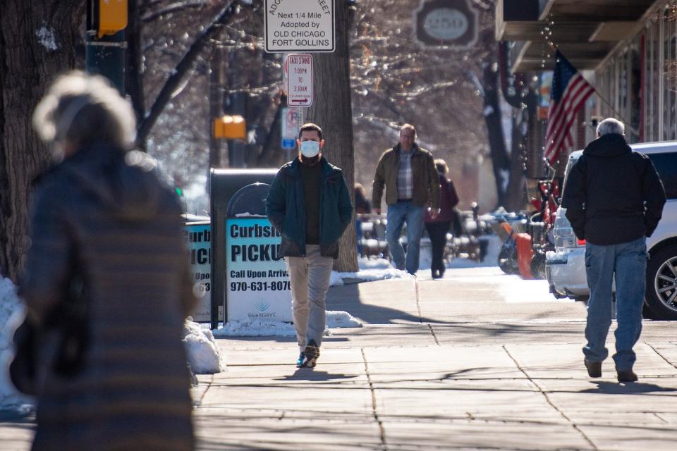 Pedestrians walk along North College Avenue in Old Town Fort Collins on Jan. 26.