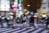 People wearing protective masks walk around the famed Shibuya scramble crossing in a shopping and entertainment district Monday, Nov. 29, 2021, in Tokyo. (AP Photo/Kiichiro Sato)