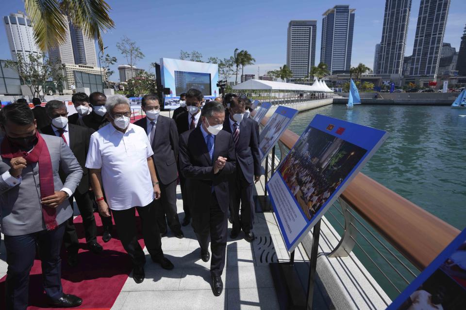 Sri Lankan President Gotabaya Rajapaksa, left, and Chinese Foreign Minister Wang Yi, center, inspect the Chinese funded sea reclamation Port City project in Colombo, Sri Lanka, Sunday, Jan. 9, 2022. (AP Photo/Eranga Jayawardena)