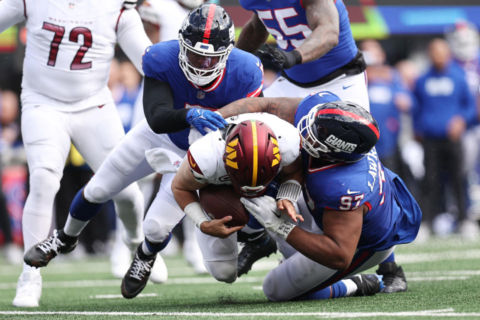 Dexter Lawrence II #97 and Kayvon Thibodeaux #5 of the New York Giants sack Sam Howell #14 of the Washington Commanders. (Photo by Dustin Satloff/Getty Images)