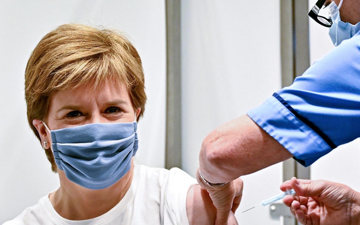 Scotland's First Minister Nicola Sturgeon receives her second dose of the Oxford/AstraZeneca Covid-19 vaccine, administered by staff nurse Susan Inglis at the NHS Louisa Jordan vaccine centre on June 21, 2021 in Glasgow. (Photo by Jeff J Mitchell / POOL / AFP) (Photo by JEFF J MITCHELL/POOL/AFP via Getty Images) - Jeff J Mitchell/AFP via Getty Images