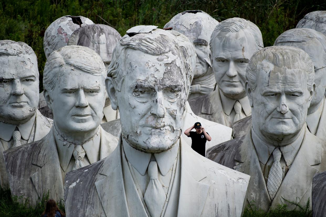 A man adjusts his had while touring the salvaged bust of US President Woodrow Wilson(front) and other busts of former US Presidents at the mulching business where they now reside August 25, 2019, in Williamsburg, Virginia.(Photo: Brendan Smialowski/AFP/Getty Images)