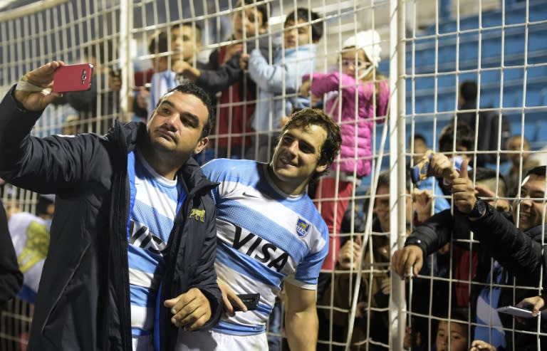Argentina's Agustin Creevy (L) and Nicolas Sanchez pose for selfies with supporters after defeating France in their rugby union Test match, at Jose Fierro stadium in Tucuman, on June 19, 2016