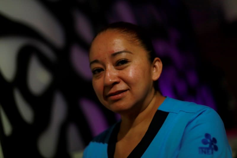Nurse Gisela Hernandez, who has stayed away from her children for nearly two months to avoid infecting them because she feels inadequately protected, poses for a photograph at her hotel room in Mexico City