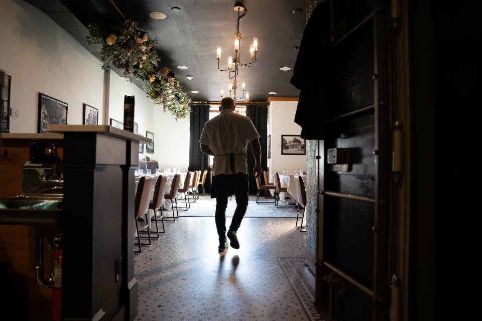 The White Linen chef Adam VanDonge emerges from the kitchen to hand off a plate of garlic focaccia as he walks through his February menu earlier this month in preparation for customers arriving later that evening.