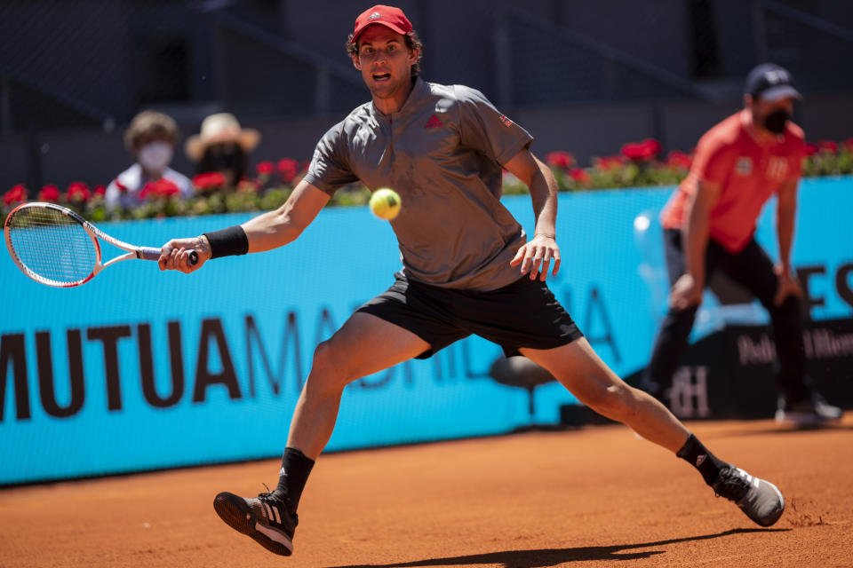 Austria's Dominic Thiem returns the ball to United States' John Isner during their match at the Mutua Madrid Open tennis tournament in Madrid, Spain, Friday, May 7, 2021. (AP Photo/Bernat Armangue)