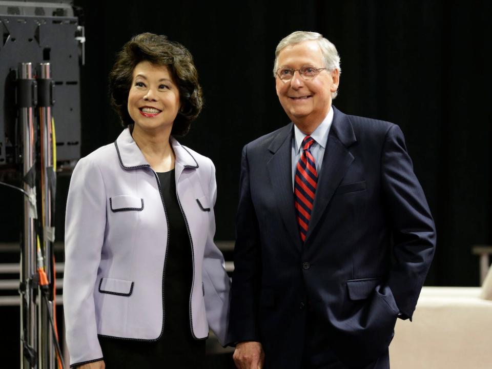 Mitch McConnell and Elaine Chao holding hands.