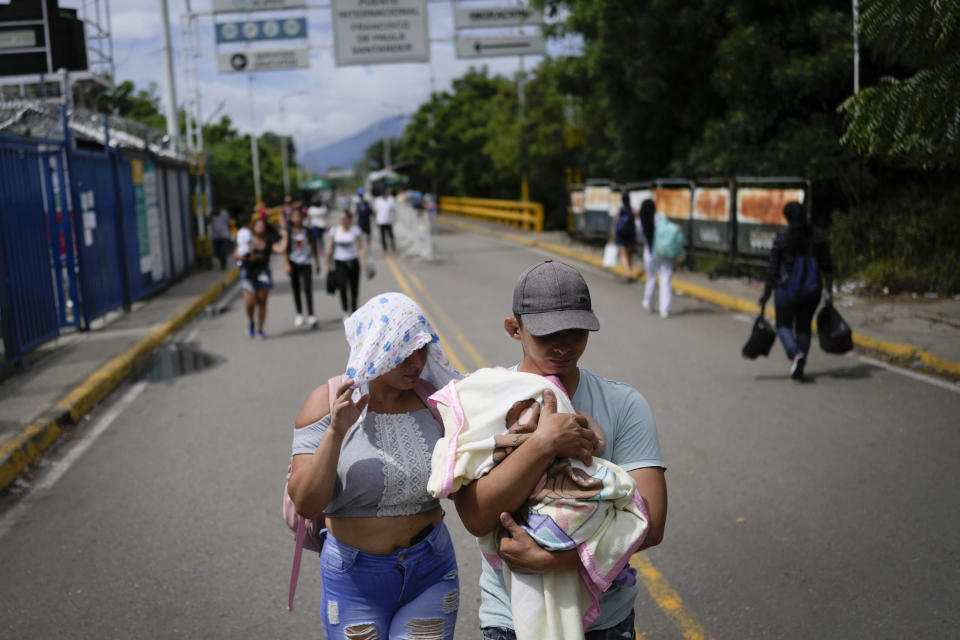 FILLE - A Venezuelan couple use the Francisco De Paula Santander Bridge to cross between Urena, Venezuela and Cucuta, Colombia, Aug. 6, 2022. The presidents of Colombia and Venezuela announced on Sept. 9 that the years-long closure of their countries' shared border to cargo transport will end Sept. 26. (AP Photo/Matias Delacroix, File)