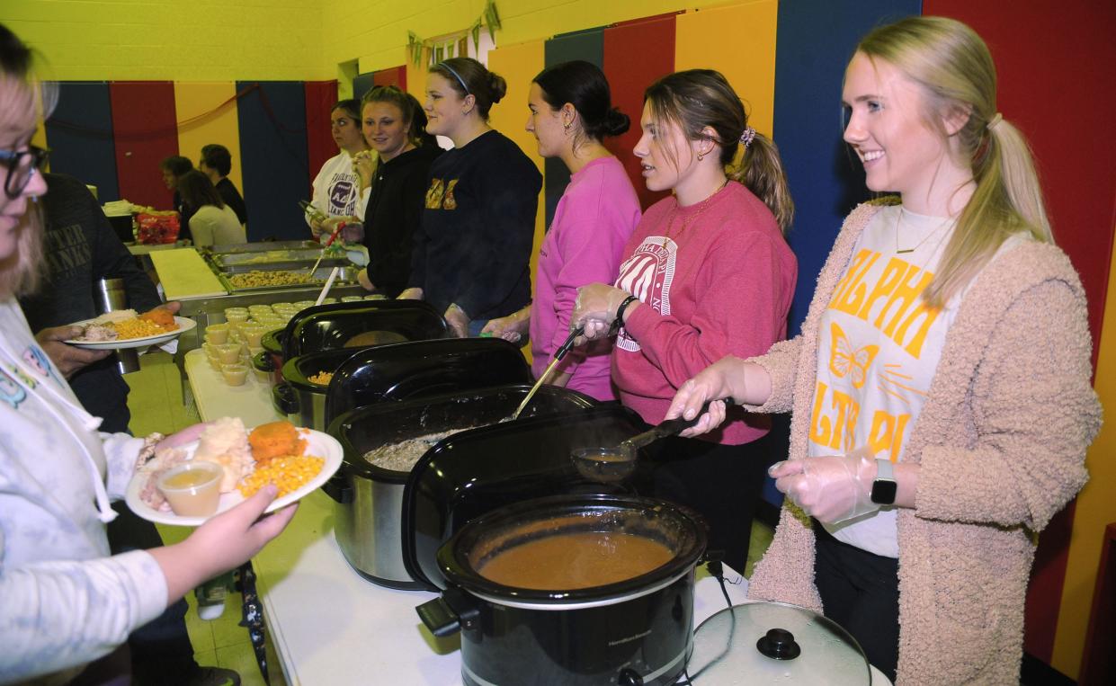 Lauren Phillips, a University of Mount Union student and member of Alpha Delta Pi sorority, smiles Sunday, Nov. 13, 2022, as she serves a guest during the annual Community Thanksgiving Luncheon at the Alliance Salvation Army.