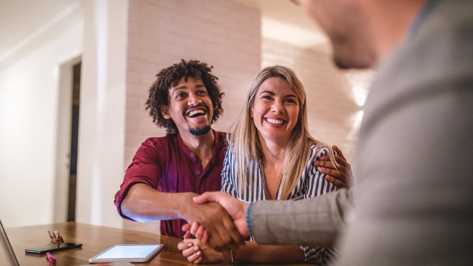 Real estate agent selling a house to young couple.