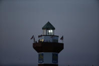 Fans watch from a lighthouse as night falls, as Webb Simpson wins on the 18th green, on a course with no fans due to the COVID-19 pandemic, during the final round of the RBC Heritage golf tournament, Sunday, June 21, 2020, in Hilton Head Island, S.C. (AP Photo/Gerry Broome)