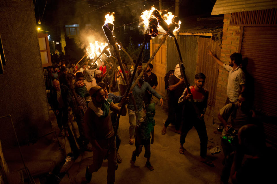 Kashmiri men shout slogans during a torch light march urging world leaders to protest against the Aug. 5 decision by Indian government to strip disputed Jammu and Kashmir of semi-autonomy and statehood, in Srinagar, Indian controlled Kashmir, Thursday, Sept. 26, 2019. (AP Photo/ Dar Yasin)