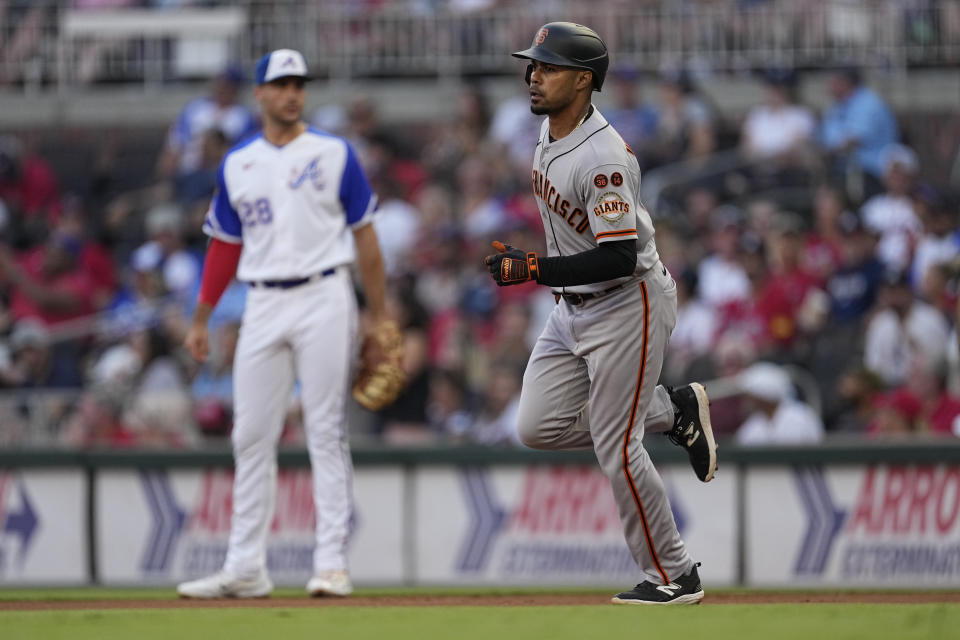 San Francisco Giants' LaMonte Wade Jr. runs past Atlanta Braves first baseman Matt Olson (28) after hitting a home run during the first inning of a baseball game Saturday, Aug. 19, 2023, in Atlanta. (AP Photo/John Bazemore)