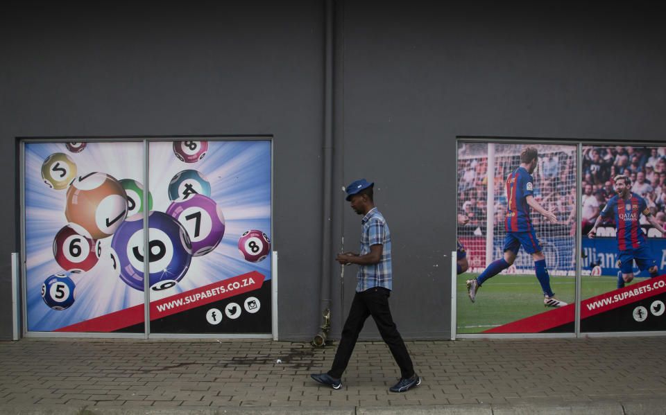 A man leaves the building of a sports betting shop in the Soweto township of Johannesburg, South Africa Thursday, Dec. 8, 2022. Although sports betting is a global phenomenon and a legitimate business in many countries, the stakes are high on the continent of 1.3 billion people because of lax or non-existent regulation, poverty and widespread unemployment. (AP Photo/Denis Farrell)