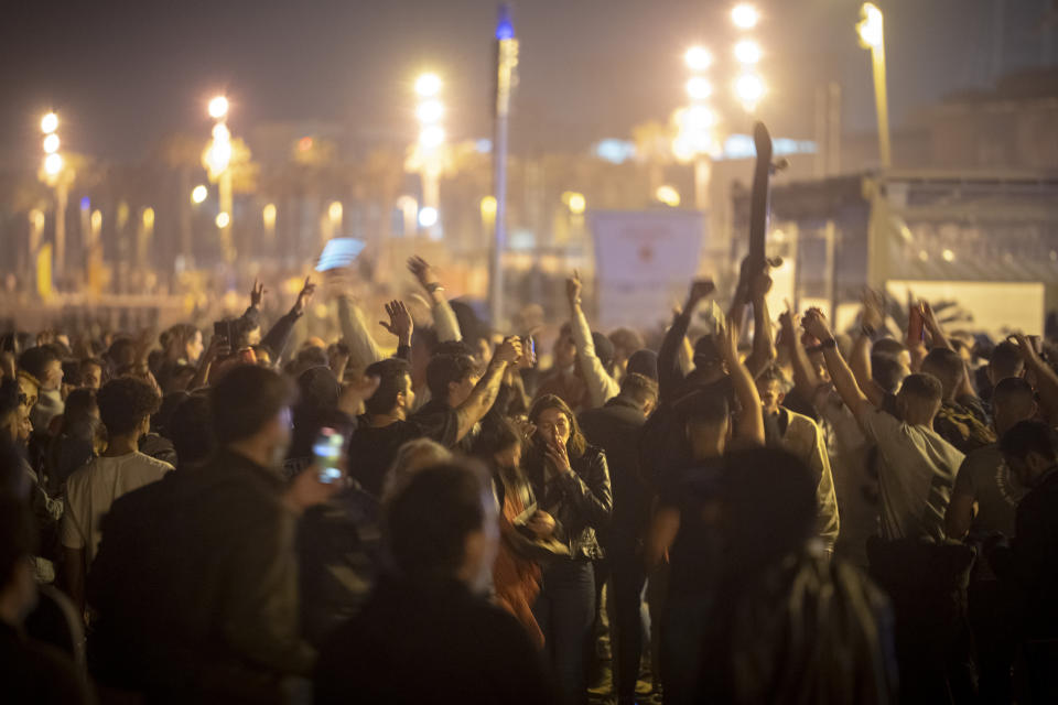 People crowded and dance on the beach in Barcelona, Spain, Sunday, May 9, 2021. Barcelona residents were euphoric as the clock stroke midnight, ending a six-month-long national state of emergency and consequently, the local curfew. Spain is relaxing overall measures to contain the coronavirus this weekend, allowing residents to travel across regions, but some regional chiefs are complaining that a patchwork of approaches will replace the six-month-long national state of emergency that ends at midnight on Saturday. (AP Photo/Emilio Morenatti)