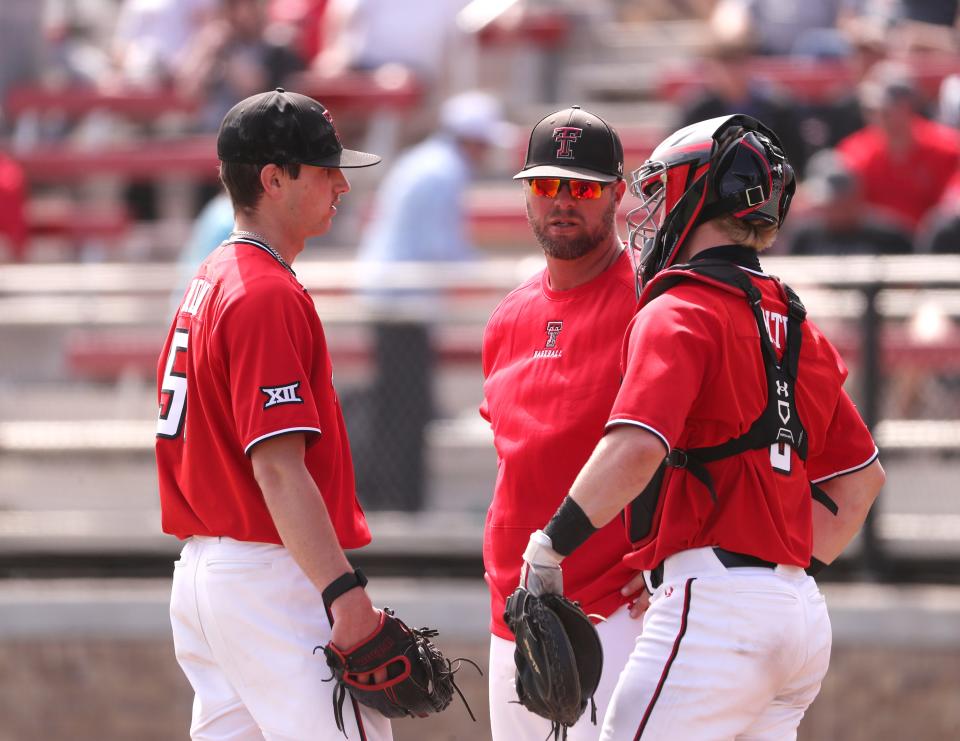 Texas Tech pitching coach Matt Gardner speaks to Texas Tech's pitcher Zach Erdman, left, and Texas Tech's catcher Hudson White (5) during the game two against UT-Arlington, Wednesday, March 15, 2023, at Dan Law Field in Rip Griffin Park.