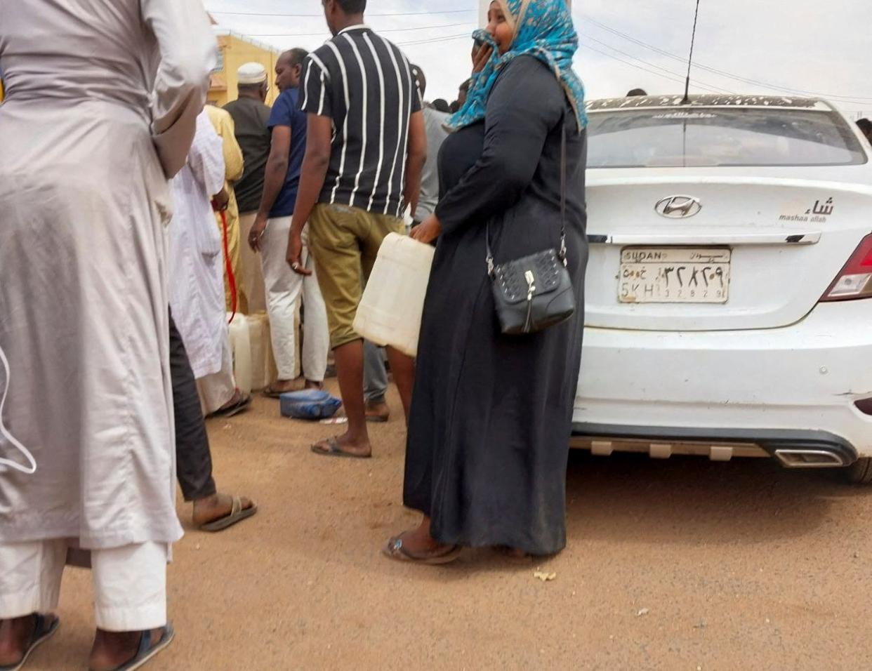 People gather to get fuel at a station, as clashes between the paramilitary Rapid Support Forces and the army continue, in south Khartoum (REUTERS)