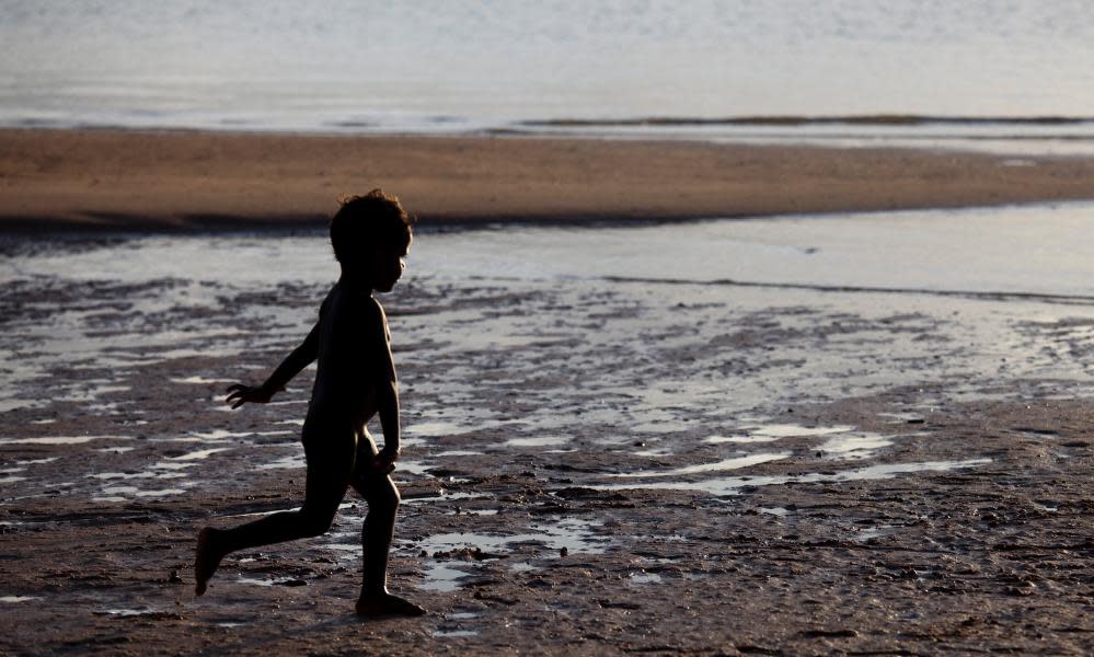Young Aboriginal boy running on beach