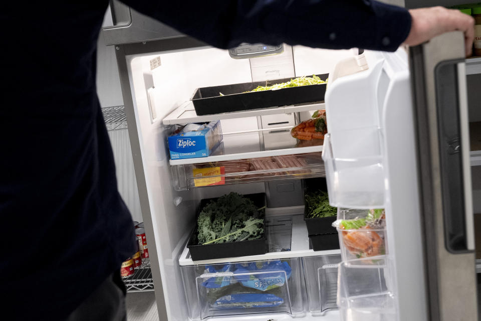 Una persona abre la puerta de una nevera en la que hay varios alimentos para estudiantes necesitados y que forman parte de una despensa de alimentos Hoya Hub en el campus de la Universidad de Georgetown el 9 de junio de 2023, en Washington, D.C. (AP Foto/Andrew Harnik)