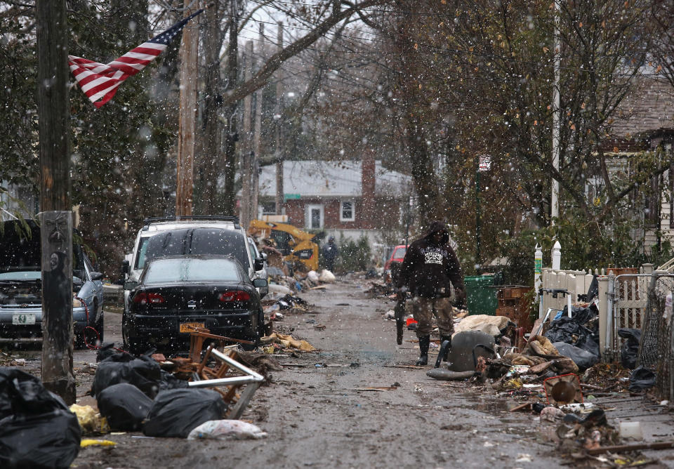 A resident clears out destroyed household belongings from his flood-damaged home as snow falls on November 7, 2012 in the Staten Island borough of New York City. (Photo by John Moore/Getty Images)