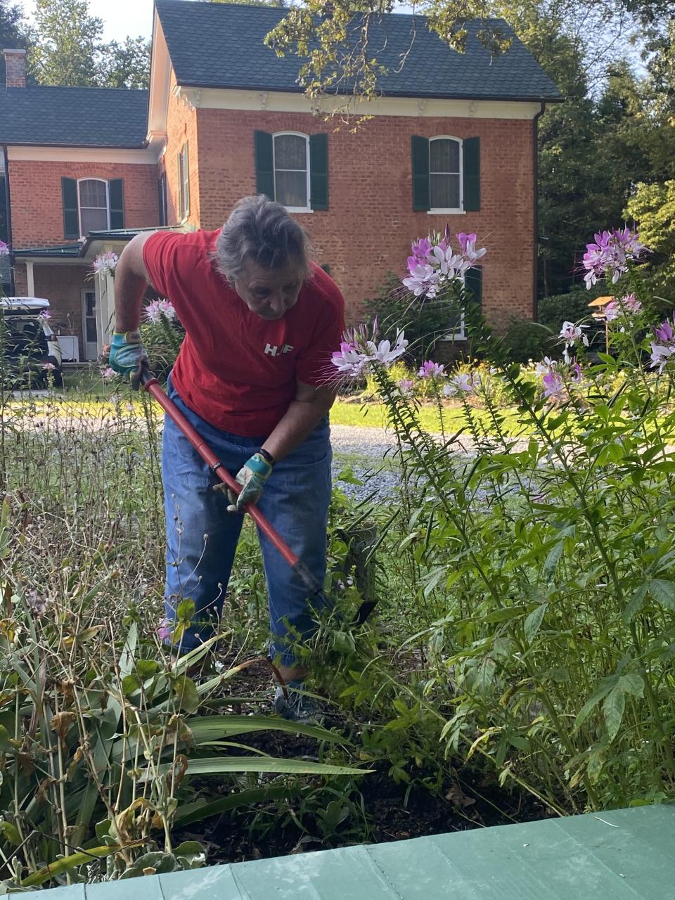 A volunteer works on the grounds of Historic Johnson Farm in Hendersonville.