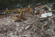 Indian rescue workers search for people in the rubble of a collapsed five-storey apartment building in Mahad. (Photo by Imtiyaz Shaikh/Anadolu Agency via Getty Images)