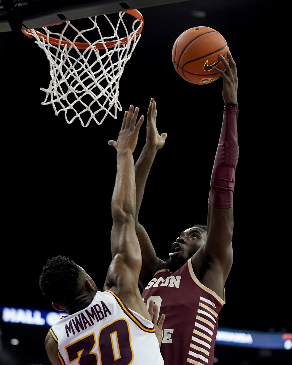 Boston College guard Prince Aligbe, right, shoots over Loyola Chicago forward Patrick Mwamba (30) during the first half of an NCAA college basketball game Thursday, Nov. 23, 2023, in Kansas City, Mo. (AP Photo/Charlie Riedel)
