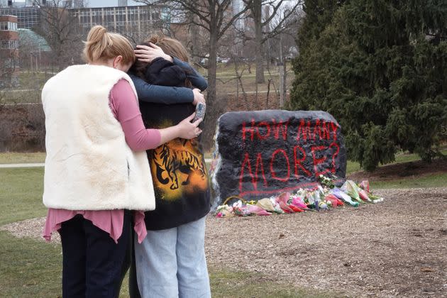 People leave flowers, mourn and pray at a makeshift memorial at 