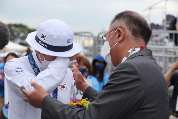 現代汽車集團會長鄭義宣（右）全程參與東京奧運，安山在個人賽奪冠後落淚，他也立刻上前鼓勵安山。（翻攝自國民日報）