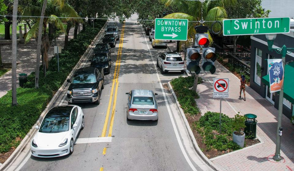 A line of vehicles wait for a green light to drive west along East Atlantic Avenue on Tuesday, May 30, 2023, in downtown Delray Beach, Fla. Atlantic Avenue is part of the area the Delray Beach Downtown Development Authority (DDA) oversees.