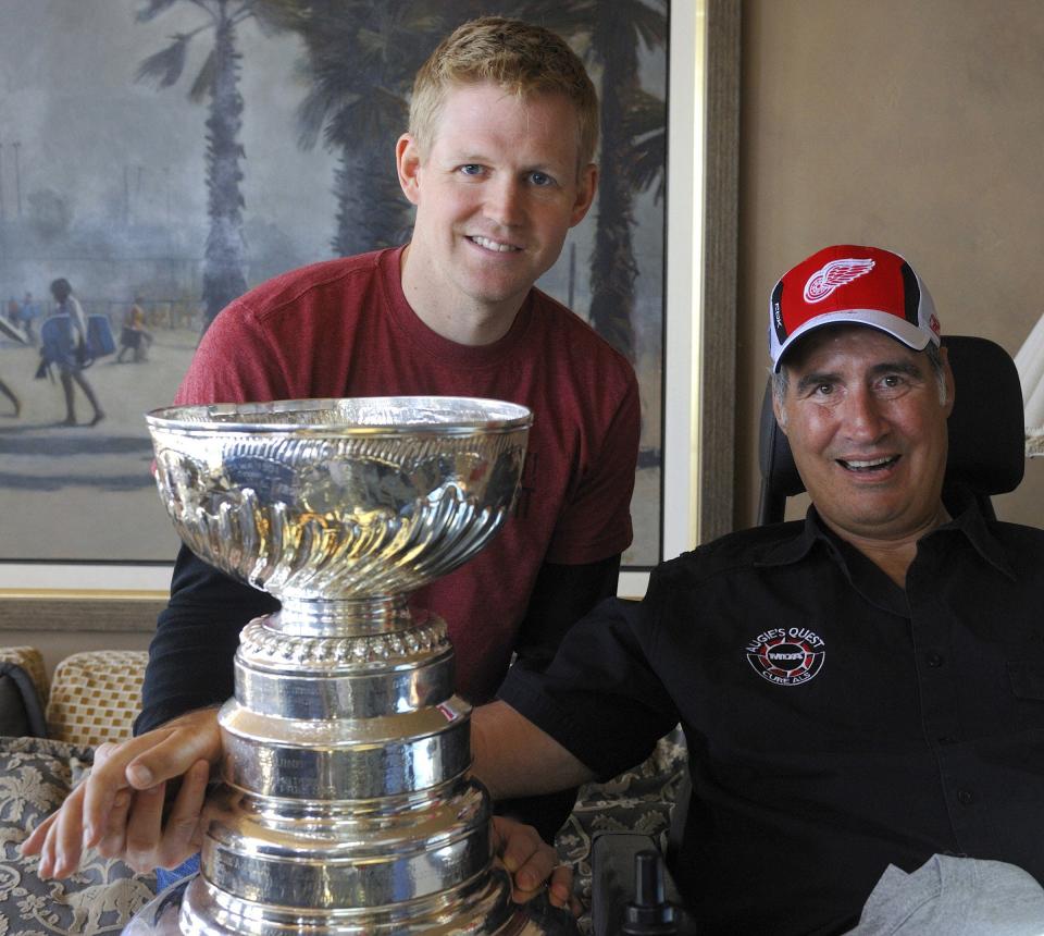 Red Wings goalie Chris Osgood, left, and Augie Nieto, who is nationally known for his struggles with Lou Gehrig's disease and his efforts to raise millions to fight for a cure, pose with the Stanley Cup after the Wings' win on June 11, 2008.