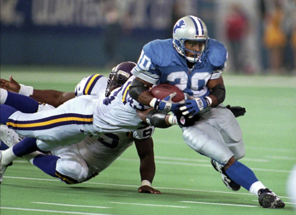Detroit Lions’ Barry Sanders makes a short gain as Minnesota Vikings’ Orlando Thomas (43) and Fernando Smith try to drag him down during the fourth quarter of an NFL football game Nov. 23, 1995, in Pontiac, Mich. (AP Photo/Jeff Kowalsky, File)