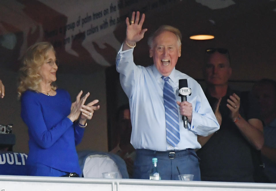 FILE - In this Oct. 20, 2016, file photo, Vin Scully acknowledges the crowd from a box before Game 5 of the National League baseball championship series between the Chicago Cubs and the Los Angeles Dodgers in Los Angeles. On Monday, April 3, 2017, the Dodgers will play their first opening day since 1950 without Scully calling their games. He won't be in the stands. He won't make a point of watching on TV, either. (AP Photo/Mark J. Terrill, File)